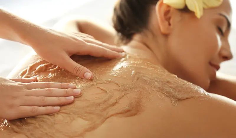Kvinna får friskvård med Coconut Body Scrub.