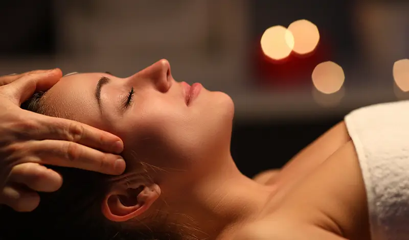 Kvinna får friskvård med Huvudmassage.