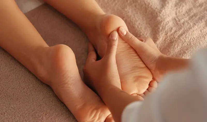 Kvinna får friskvård med fotmassage.