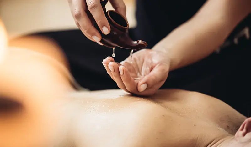 Kvinna får friskvård med klassisk oljemassage.