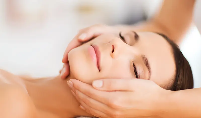 Kvinna får friskvård med Huvud & ansiktsmassage.
